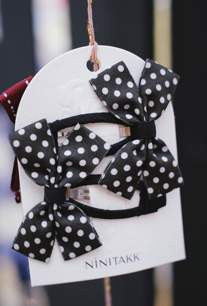 A set of two black bows with white polka dots, playful and stylish.