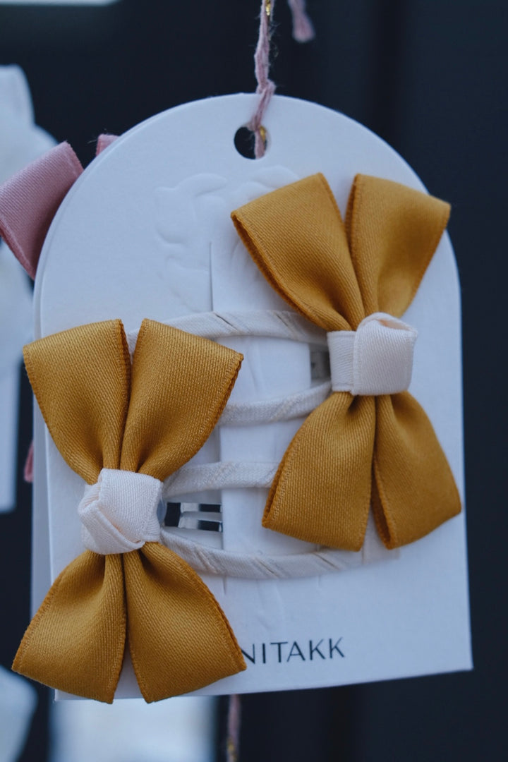 A set of cheerful yellow bow hair clips, perfect for brightening any outfit.