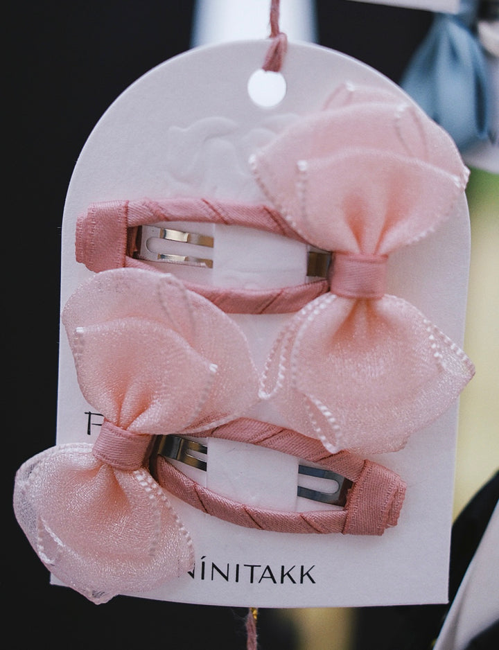 A set of gentle blush pink bow hair clips, adding a soft and tender touch.