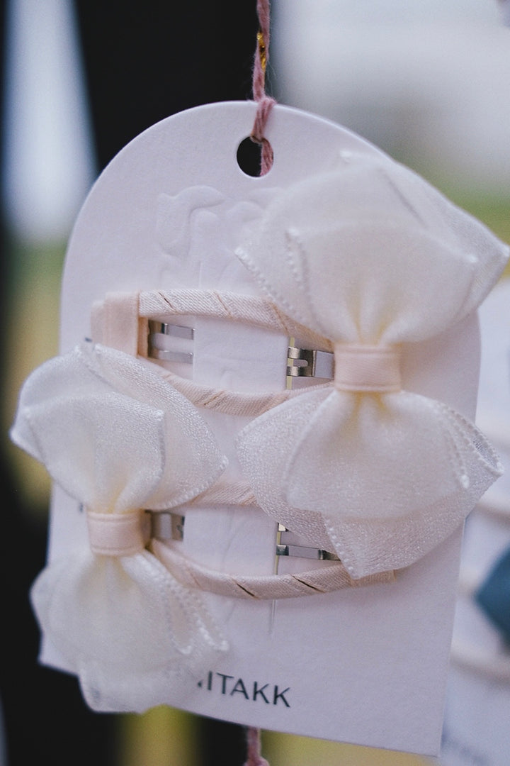 A set of pristine white bow hair clips, offering a classic and elegant style.