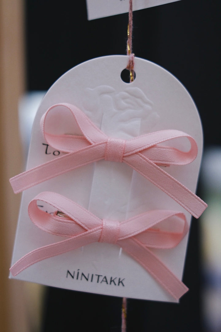 Light pink bow hair clips, featuring a subtle and elegant design. These clips offer a soft, understated touch to your child’s hairstyle.