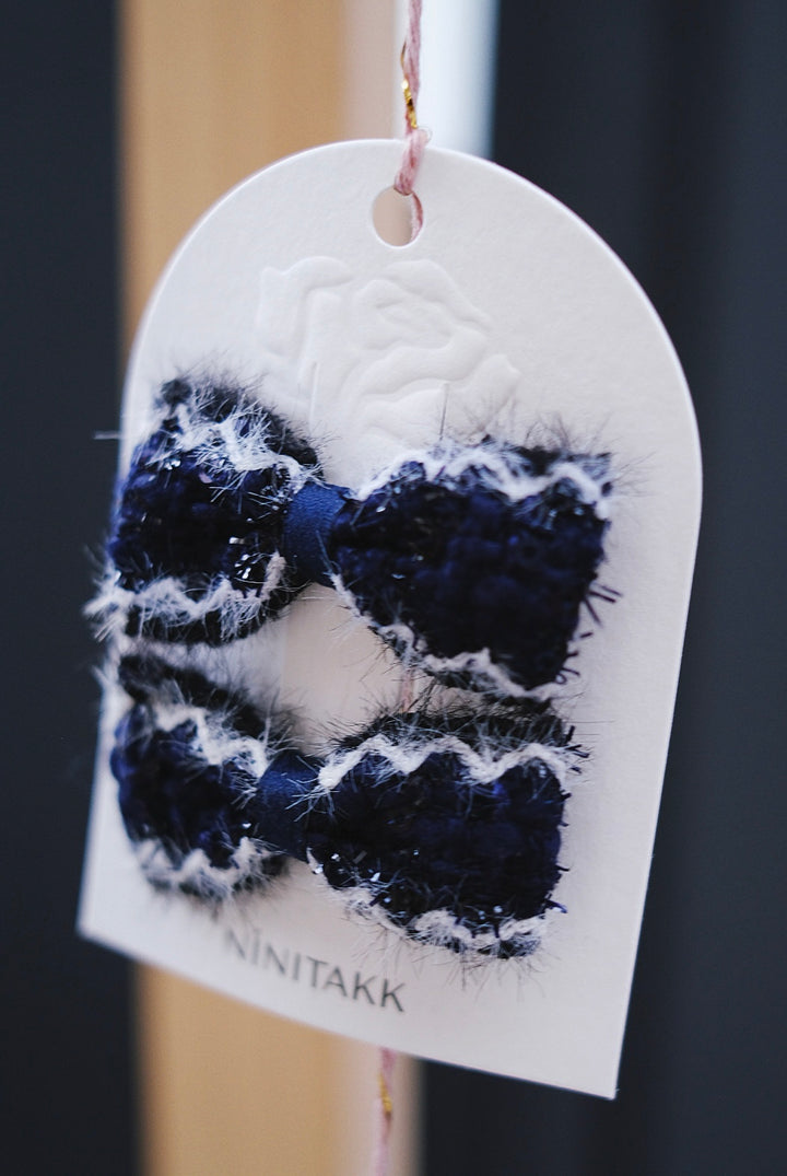 A deep navy blue fluffy bow, offering a rich and sophisticated appearance.