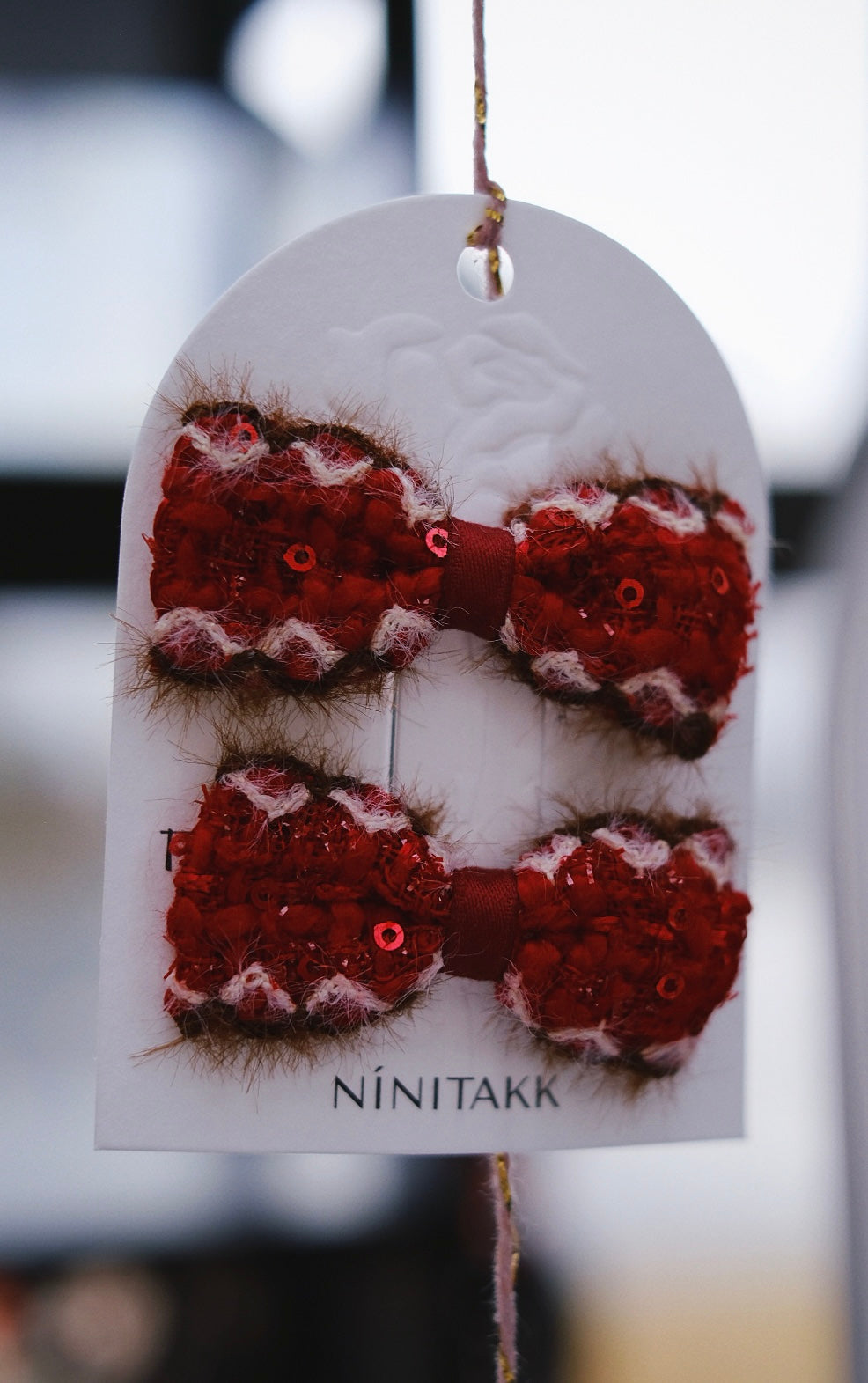 A vibrant red fluffy bow, perfect for adding a festive and cheerful pop of color to winter outfits.