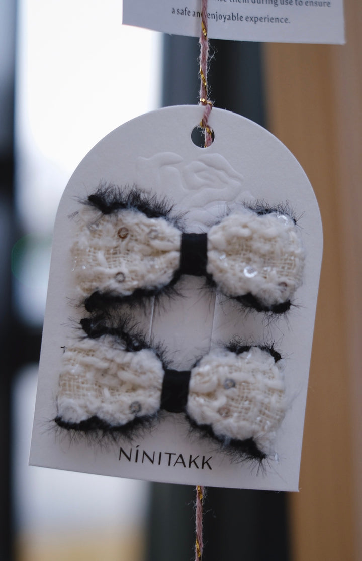 A pristine white fluffy bow, adding a clean and elegant look reminiscent of fresh snow.