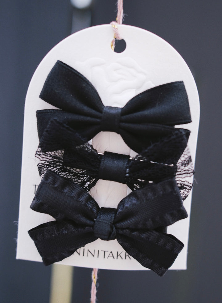 A sophisticated set of black bows, featuring a mix of satin and lace textures for a chic look.