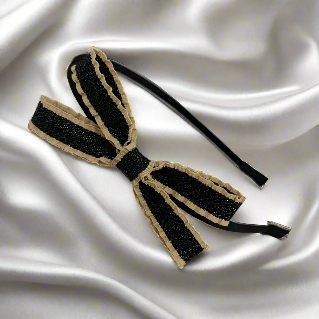 Highlighting the intricate details, this side view reveals the textured layers and ruffled edges of the black and beige bow. The 9 cm double-layer fabric bow adds dimension and flair to the sturdy iron headband, perfect for various occasions.