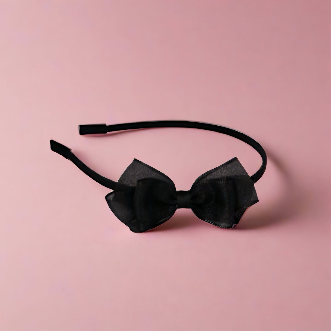 This elegant headband features a small, triple-layer silk yarn bow in classic black, offering a subtle yet sophisticated accessory for any girl's wardrobe. The bow measures approximately 8 cm.