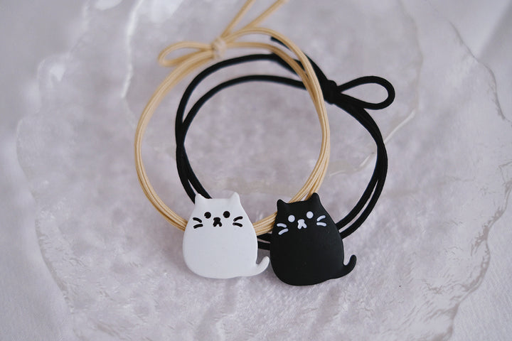 The black and white color options offer versatility, while the charming feline motifs add a playful touch to any hairstyle.