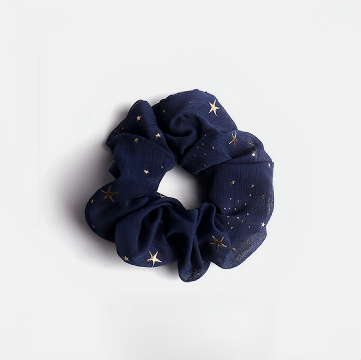 This navy blue hair scrunchie is dotted with golden stars just like the night sky.