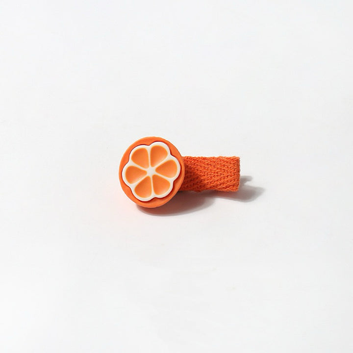 A close-up of the orange hair clip, featuring a bright orange and white design with a cheerful orange fabric wrap.