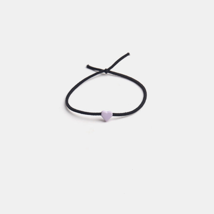 The Tiny Heart hair tie in a soft pastel purple color.