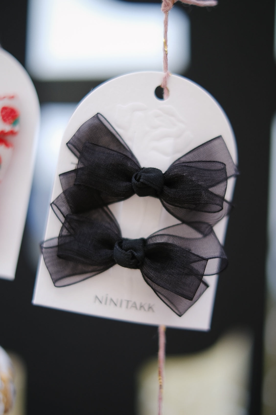Elegant black hair clips with delicate translucent bows, perfect for adding a sophisticated touch. These clips beautifully complement blonde hair, creating a striking contrast.