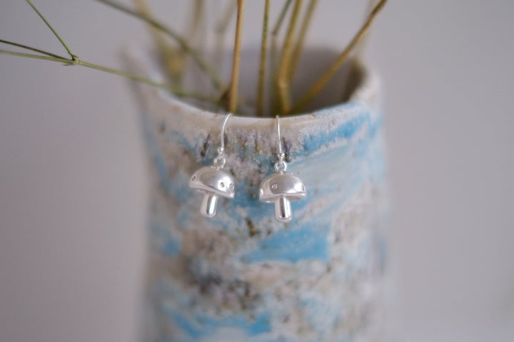 Detailed shot of the sterling silver mushroom earrings, highlighting their playful and elegant design.