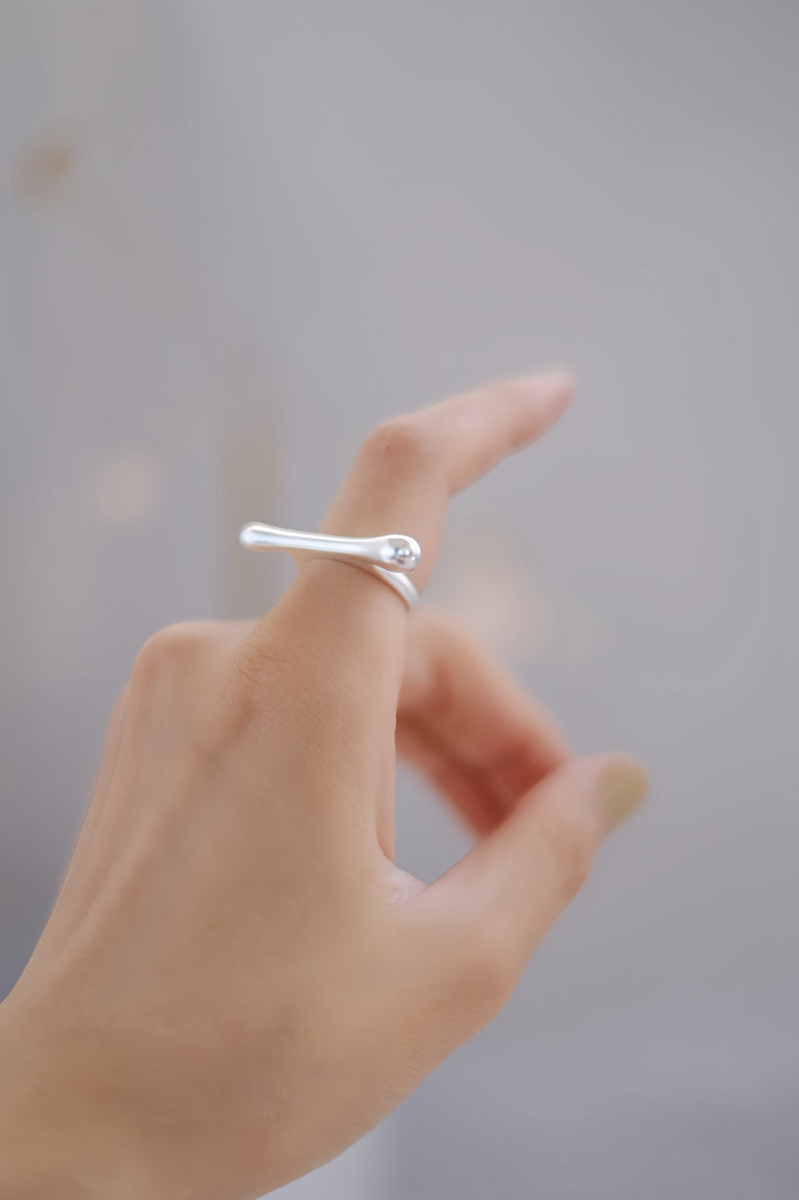 The Bone sterling silver ring worn on a woman's hand, showcasing its elongated, bold design. The sleek, polished surface catches the light, making it a striking statement piece for any contemporary jewelry lover.