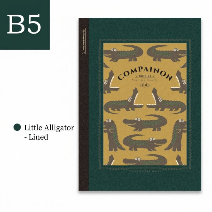 B5 lined notebook with a green alligator print cover on a dark forest green background.