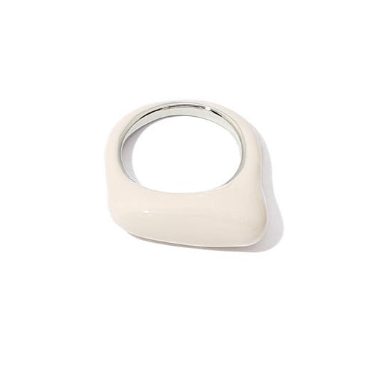 The white enamel ring is displayed in a close-up image, showcasing its glossy, smooth finish. The serene, creamy color adds a touch of sophistication to its clean, geometric shape.