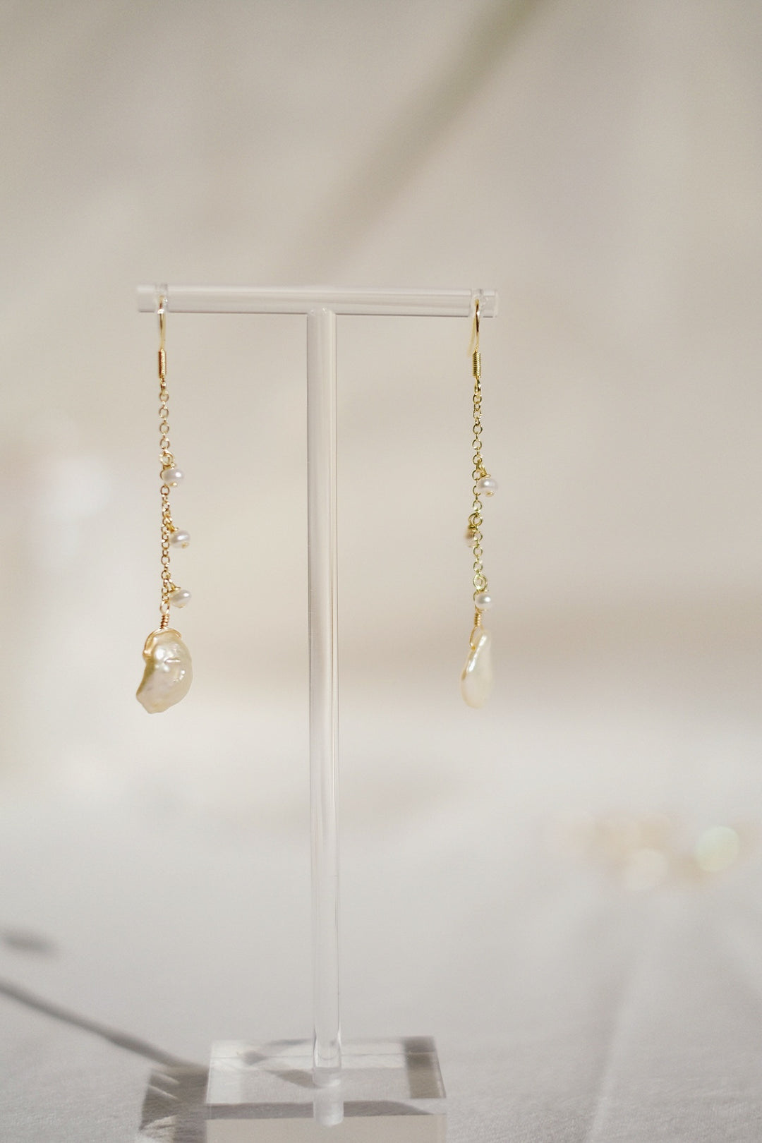 The Enchanted Woodland Hook Earrings placed on a earring stand in a sunlit corner, evoking a fairy-tale-like charm and the natural beauty of their design.