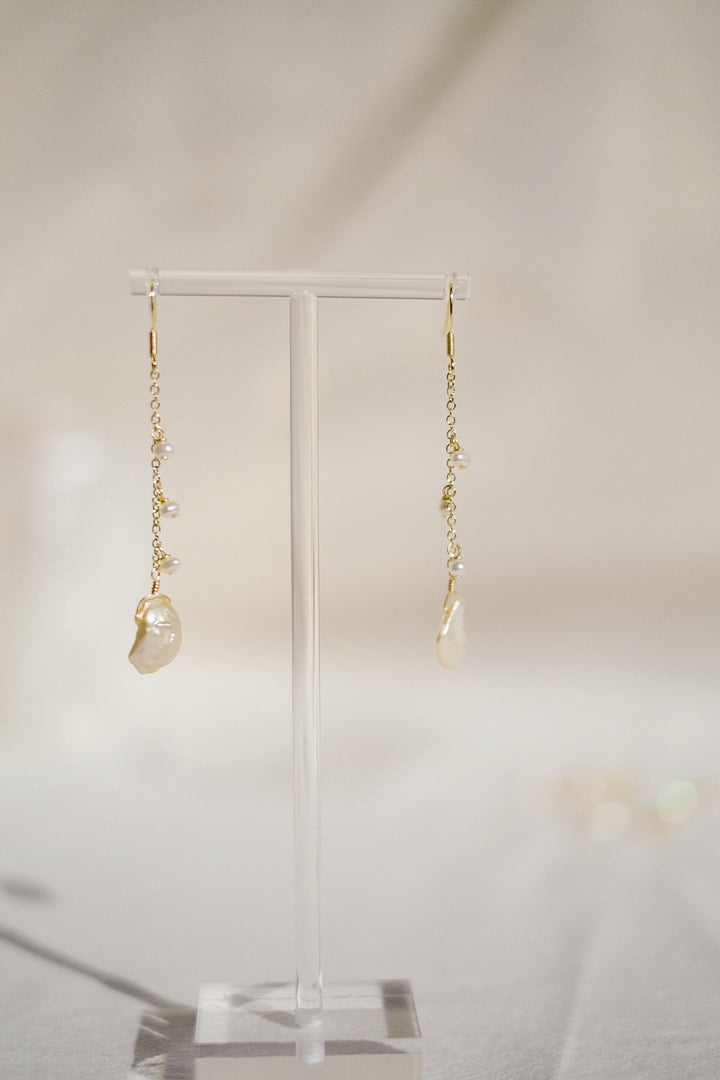 The Enchanted Woodland Hook Earrings placed on a earring stand in a sunlit corner, evoking a fairy-tale-like charm and the natural beauty of their design.