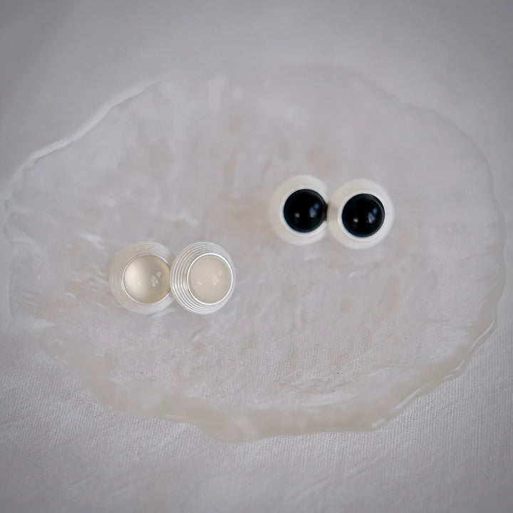 See the Goddess Stud Earrings in both gemstone options – white agate and black onyx. This image captures the serene balance between the light, ethereal quality of the white agate and the dark, enigmatic allure of the black onyx.