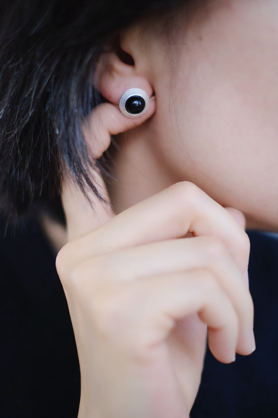 The Goddess Stud Earrings are styled with a black modern outfit, demonstrating their versatility and timeless appeal. Whether worn with casual or formal attire, these earrings add a touch of grace and balance.