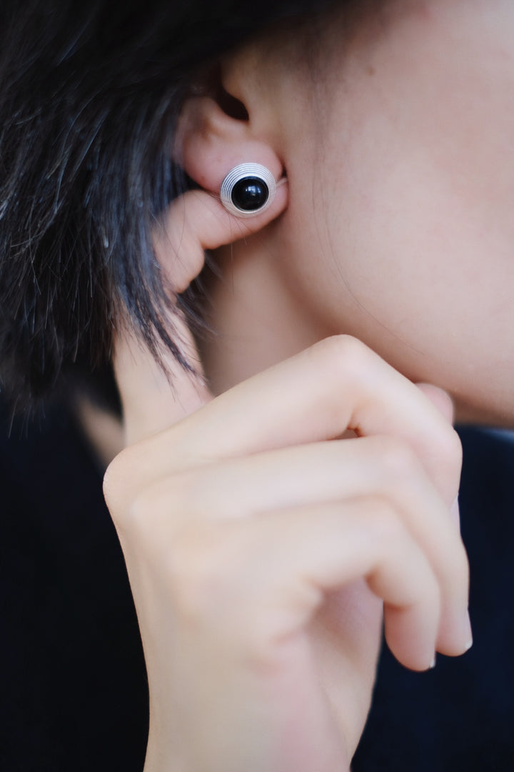 The Goddess Stud Earrings are styled with a black modern outfit, demonstrating their versatility and timeless appeal. Whether worn with casual or formal attire, these earrings add a touch of grace and balance.