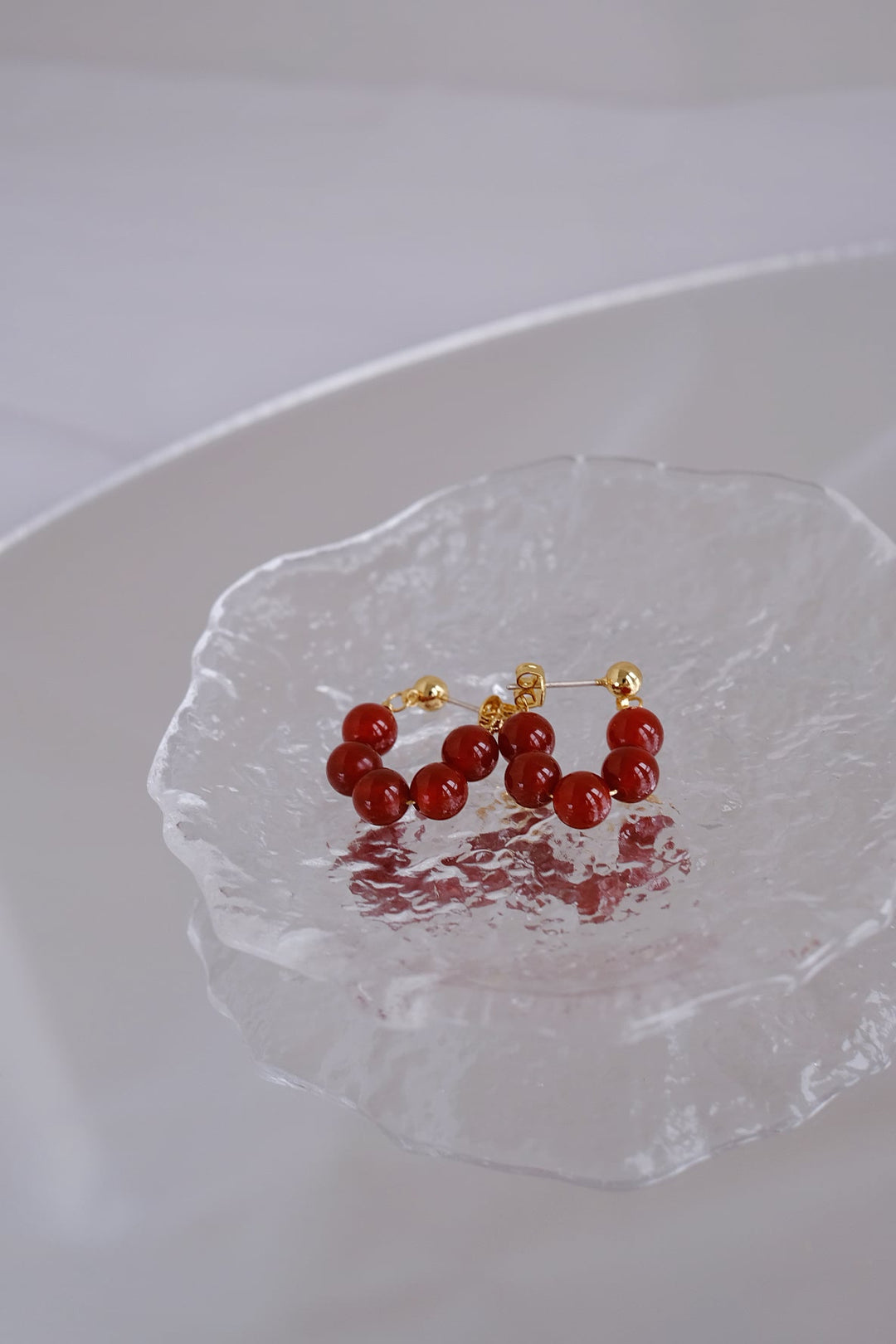 Detailed image of the 6mm onyx bead earrings, emphasizing the rich red hue and 18k gold plated silver.