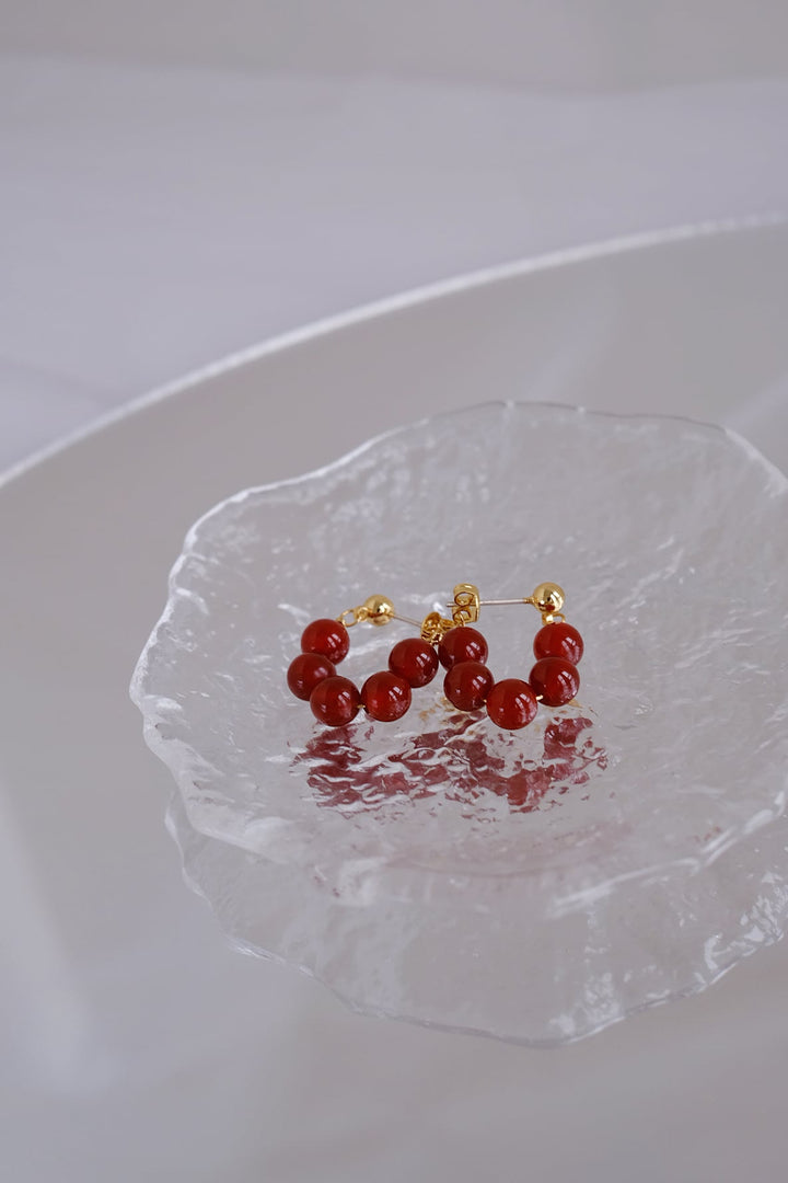 Detailed image of the 6mm onyx bead earrings, emphasizing the rich red hue and 18k gold plated silver.