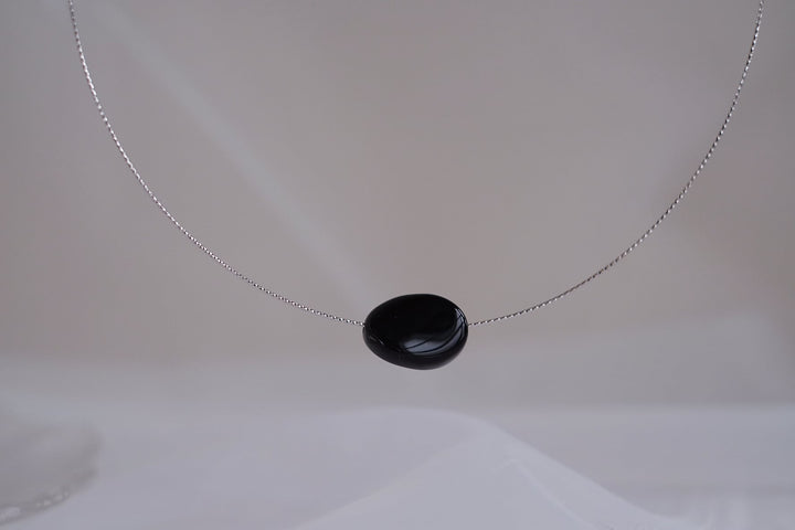 The silver chain and the black onyx pendant strike a sharp contrast of colors.