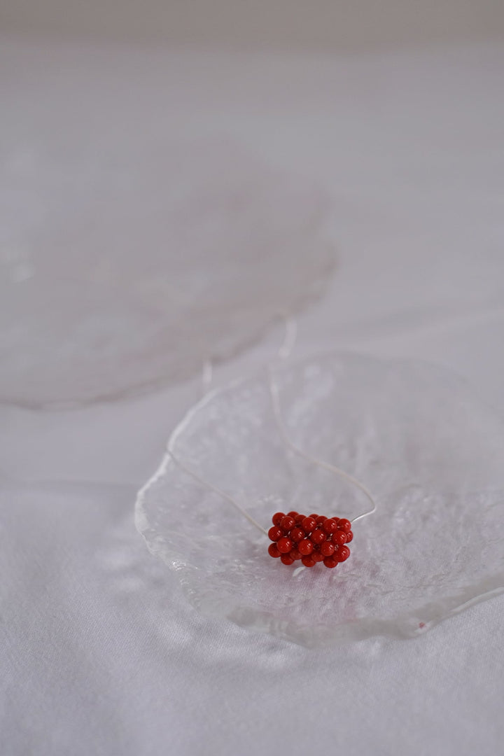 Sweet Raspberry necklace displayed on a glass dish.