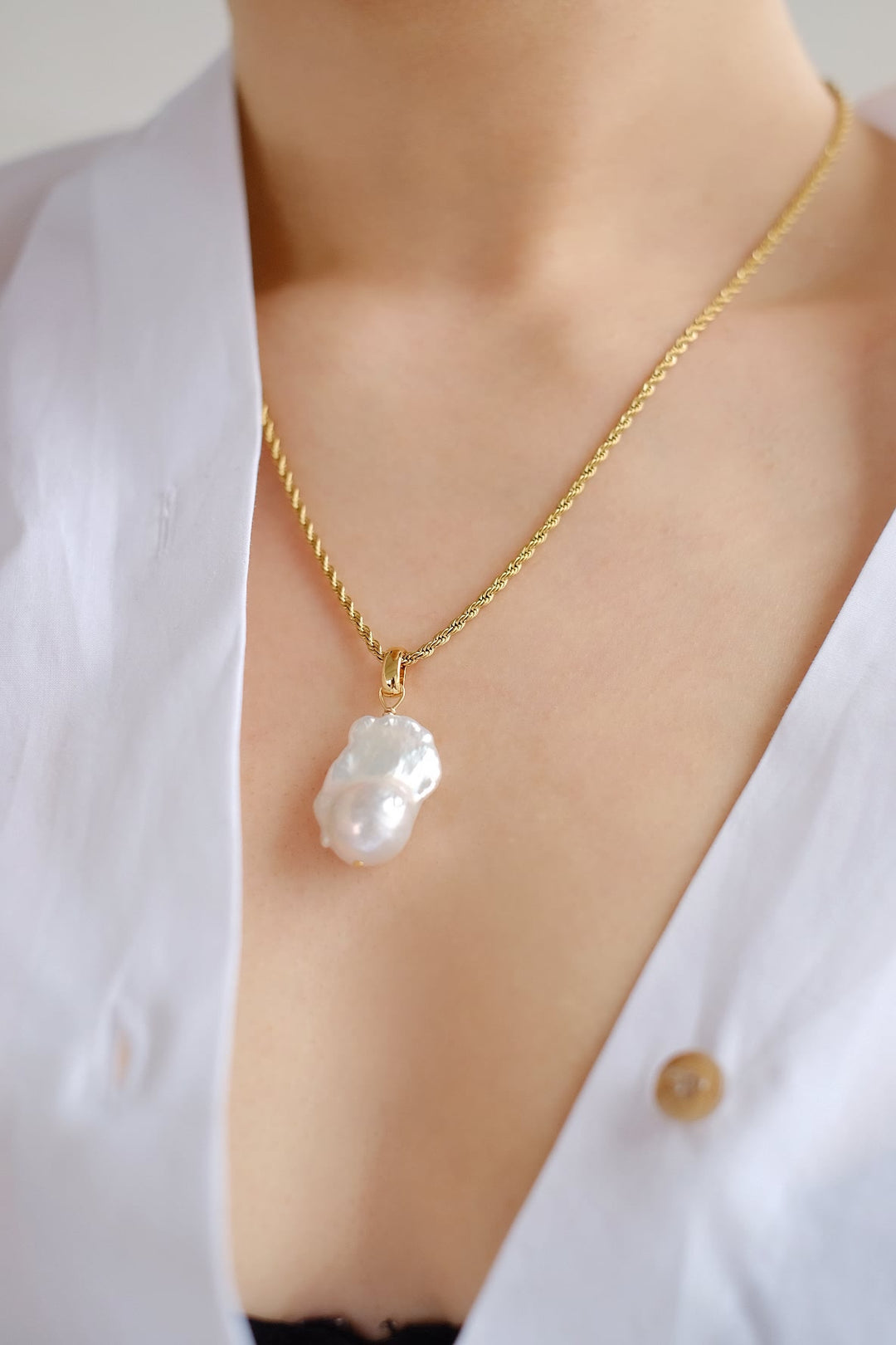 Capture attention with our exquisite baroque pearl pendant necklace, featuring a sizable pearl suspended from a shimmering gold chain.