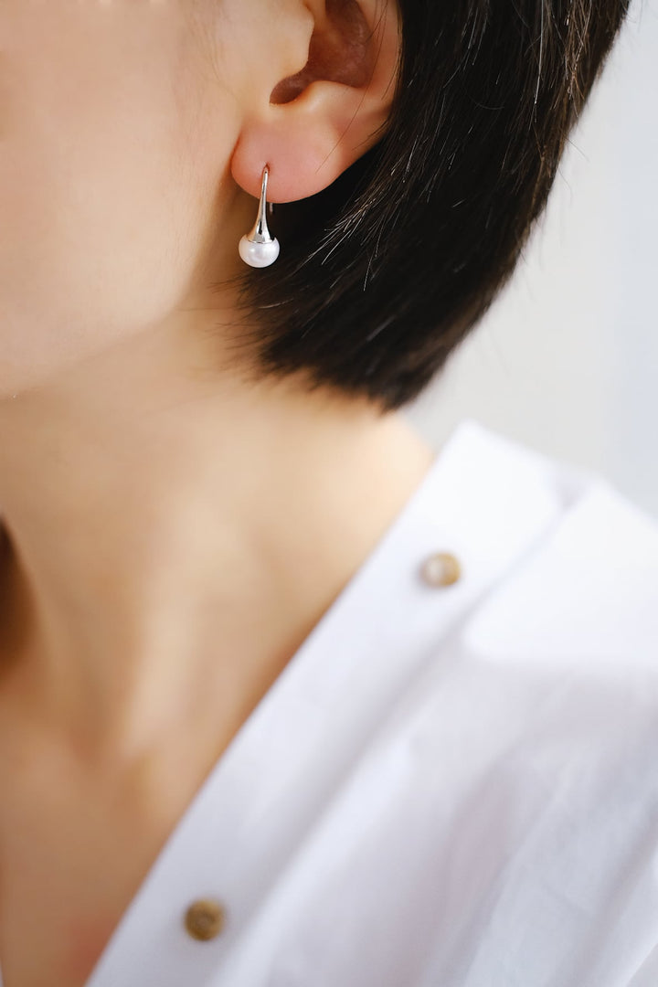 A close-up of the earrings worn on the left ear, demonstrating their perfect size and fit.