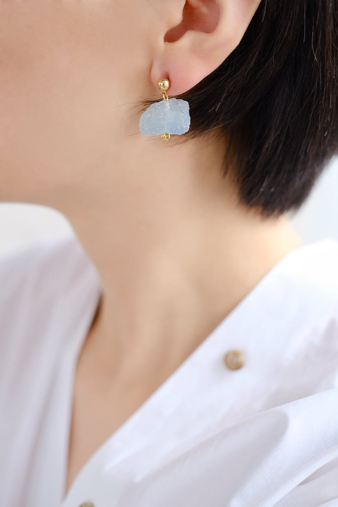 An image of a person with the blue aquamarine earring, highlighting its soothing effect and ability to enhance communication.