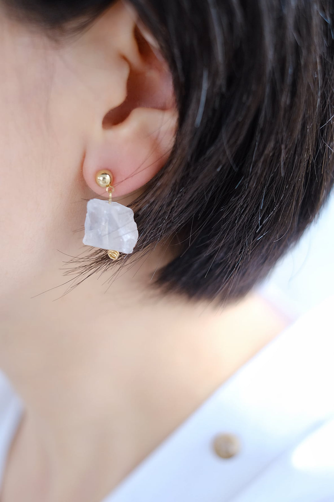 A person wearing the white clear quartz earring, emphasizing its clarity-enhancing and energy-amplifying benefits.