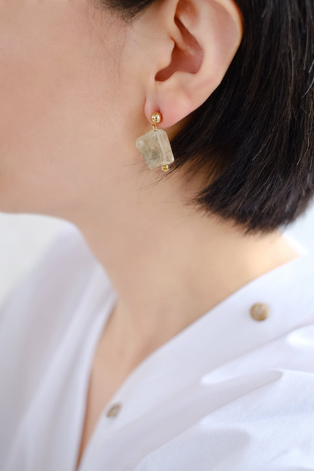 A person wearing the yellow citrine earring, showcasing its ability to attract prosperity and boost self-confidence.