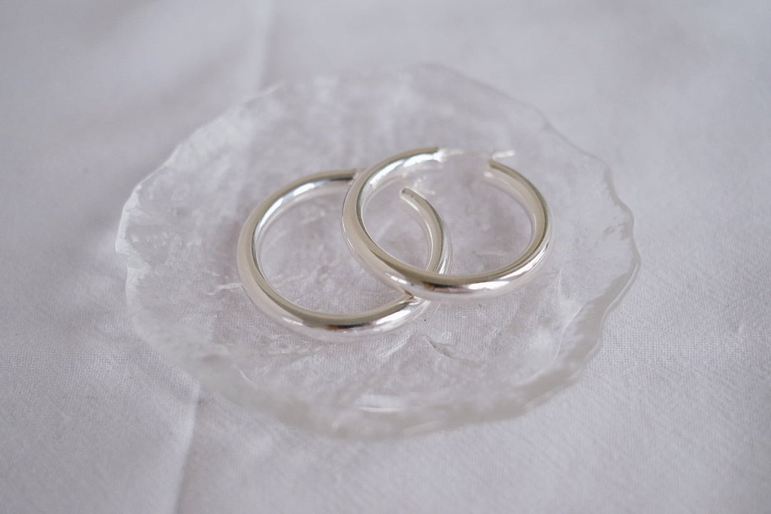 Detailed view of the earrings alone, laid flat on a white background, displaying the high-quality sterling silver material and craftsmanship.