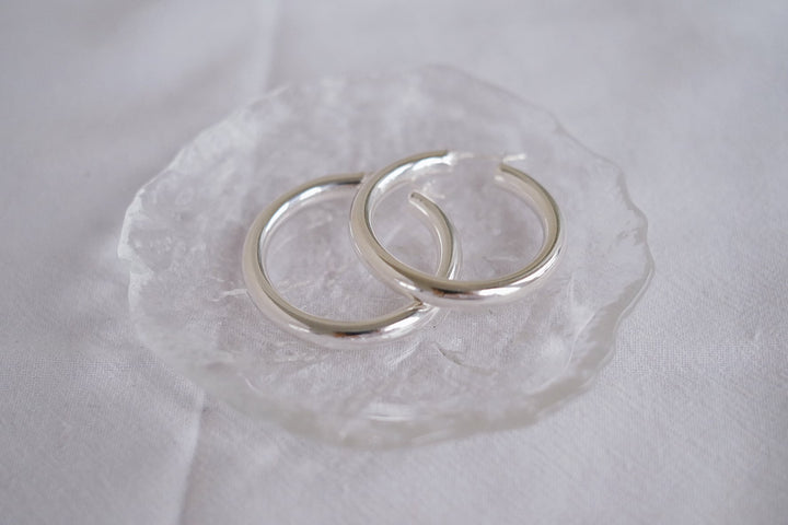 Detailed view of the earrings alone, laid flat on a white background, displaying the high-quality sterling silver material and craftsmanship.