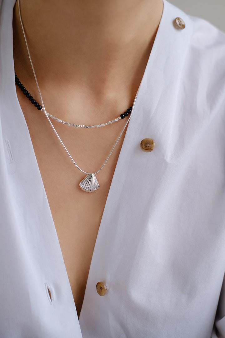 The Ice Beach necklace paired with a cute seashell silver necklace. The black onyx stones add an edge to the look.