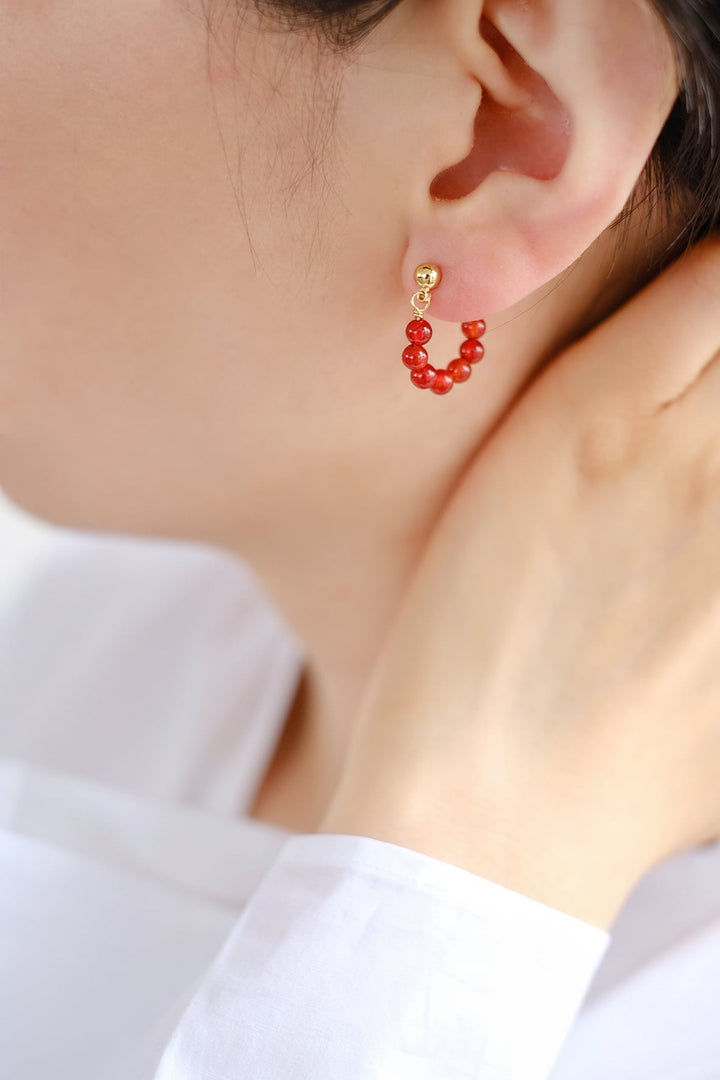 A model wearing the 4mm onyx bead earrings, illustrating how they dangle elegantly from the ear.