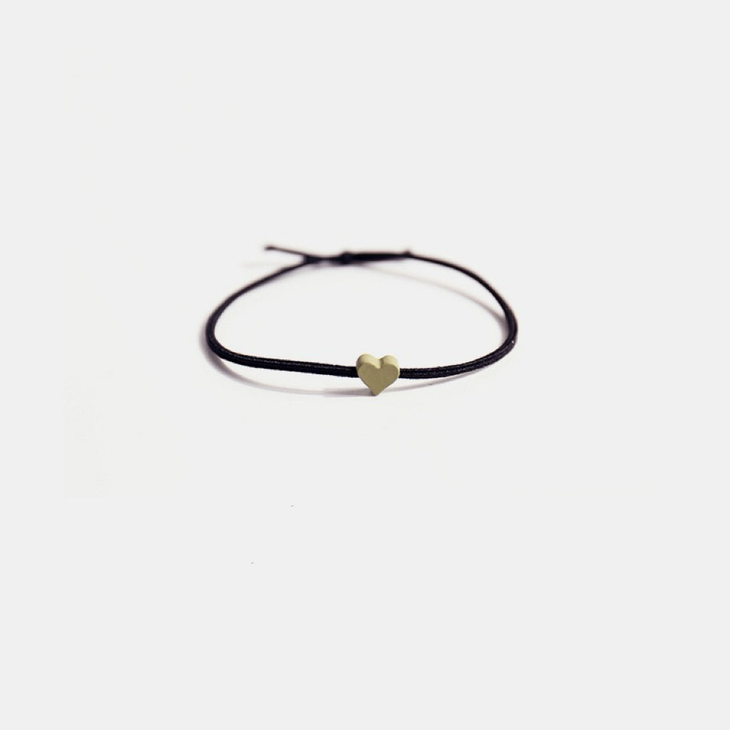 The Tiny Heart hair tie in a soft green color.