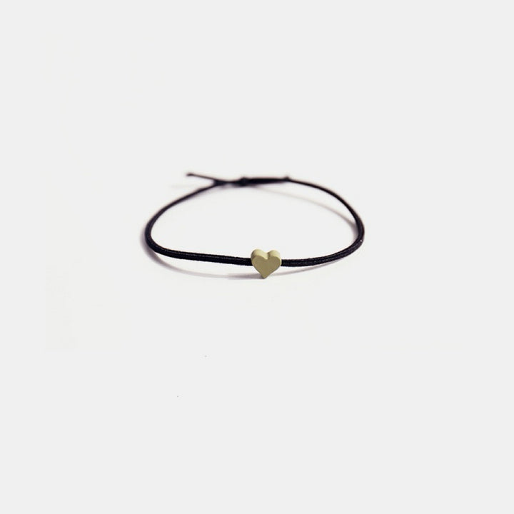 The Tiny Heart hair tie in a soft green color.