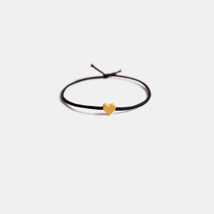 Close-up of a single hair tie with a tiny yellow heart, showcasing its cute and colorful design.