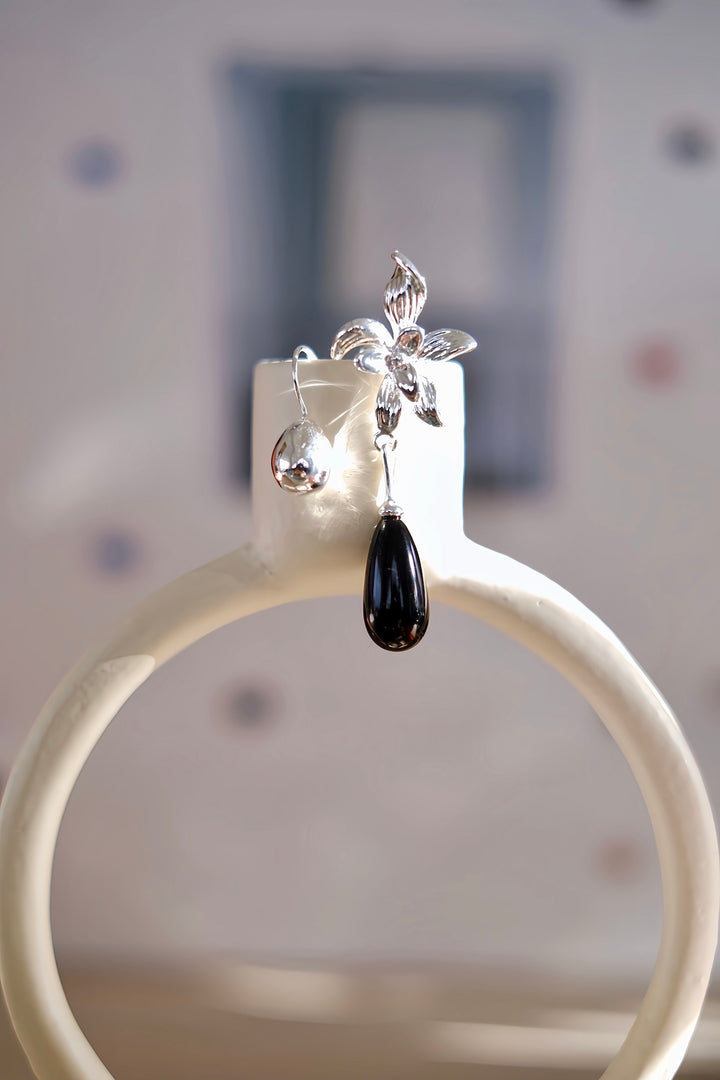 A single Daffodil earring showcased on a soft blue background, emphasizing the intricate craftsmanship and the lightweight design, perfect for all-day wear.
