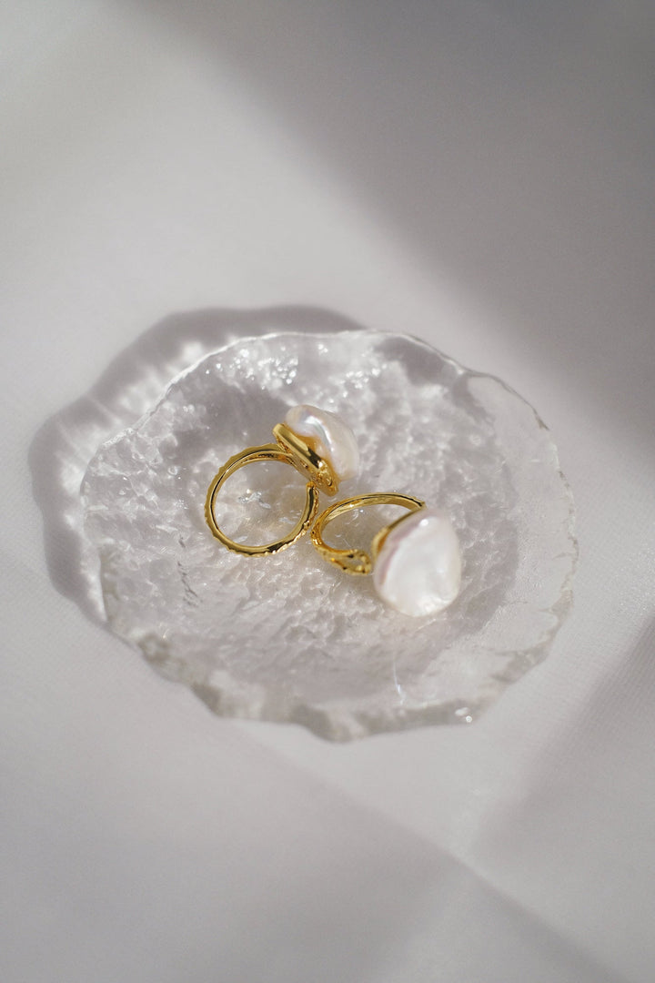 The exquisite craftsmanship of the double-layer gold bands complements the beauty of the baroque pearls.