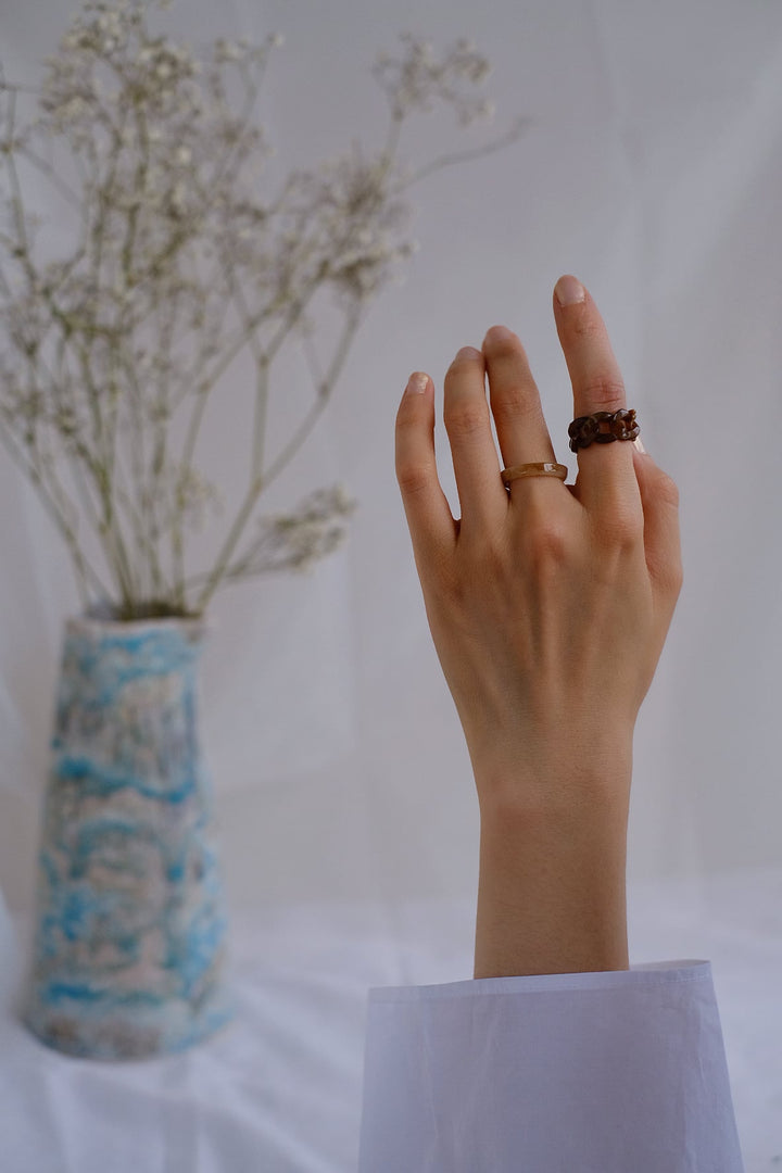 In this image, the beige band and the coffee-colored interwoven ring from the Sand Dunes set are shown worn together. The warm, earthy tones blend seamlessly with the skin, offering a subtle yet sophisticated look that complements any outfit.