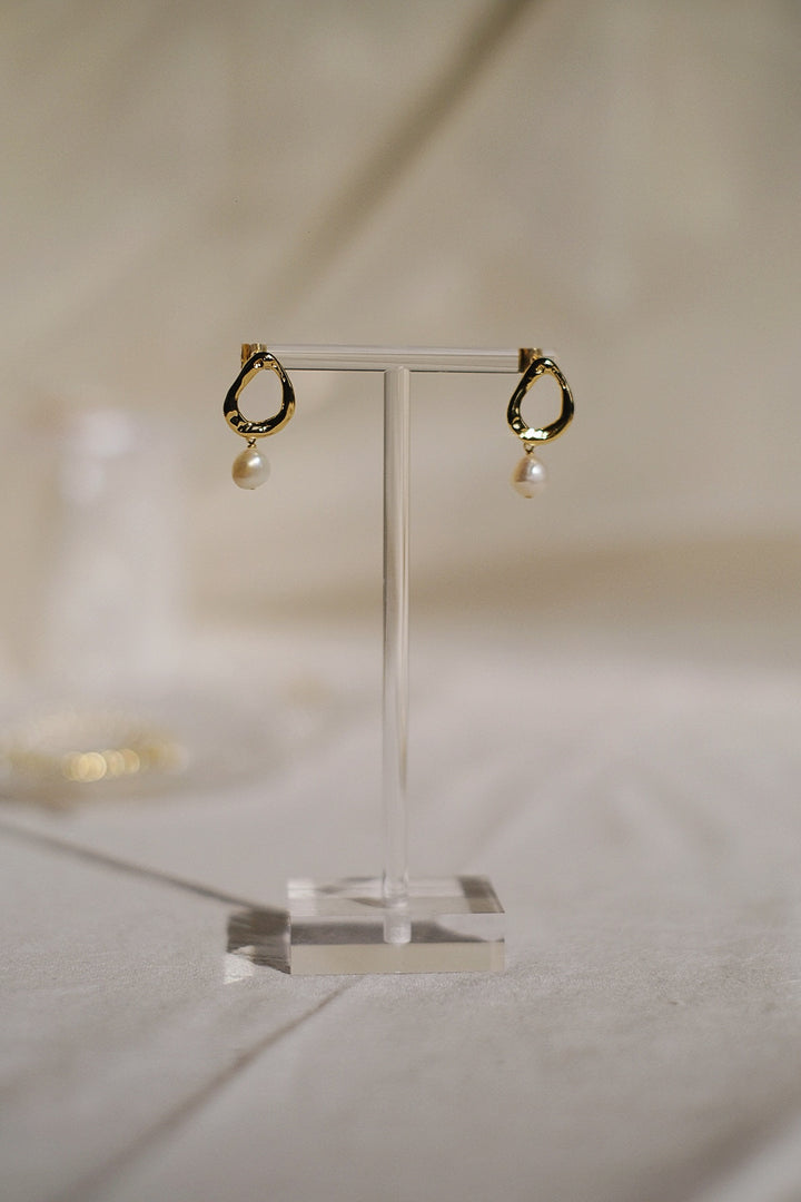 The earrings hanging naturally, illustrating how the pearls dangle and move with grace.