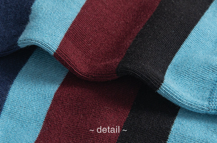 A detailed view of the fabric, highlighting the blend of burgundy, navy, and light blue stripes with a focus on the seamless stitching and texture.