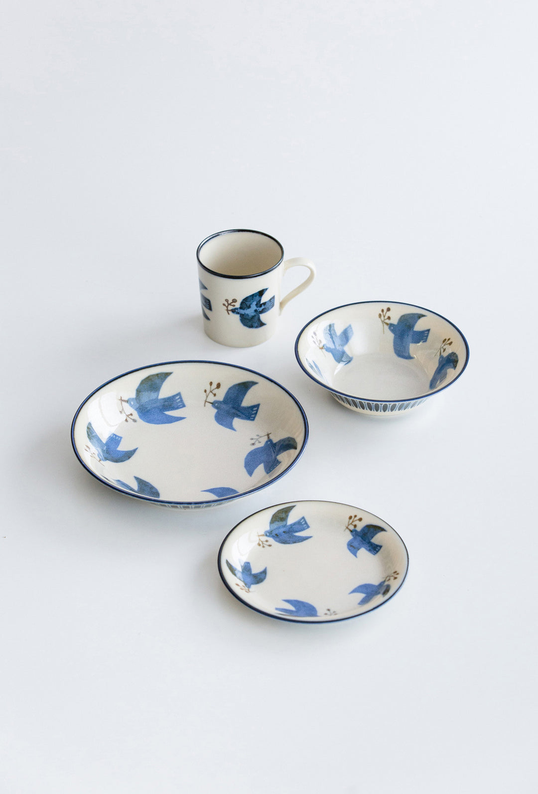 A group shot featuring the entire Minoyaki series, including the seabird design plates and coordinating mugs. The various pieces are arranged together, showcasing the cohesive and charming aesthetics of the collection, ideal for enhancing any homeware set.