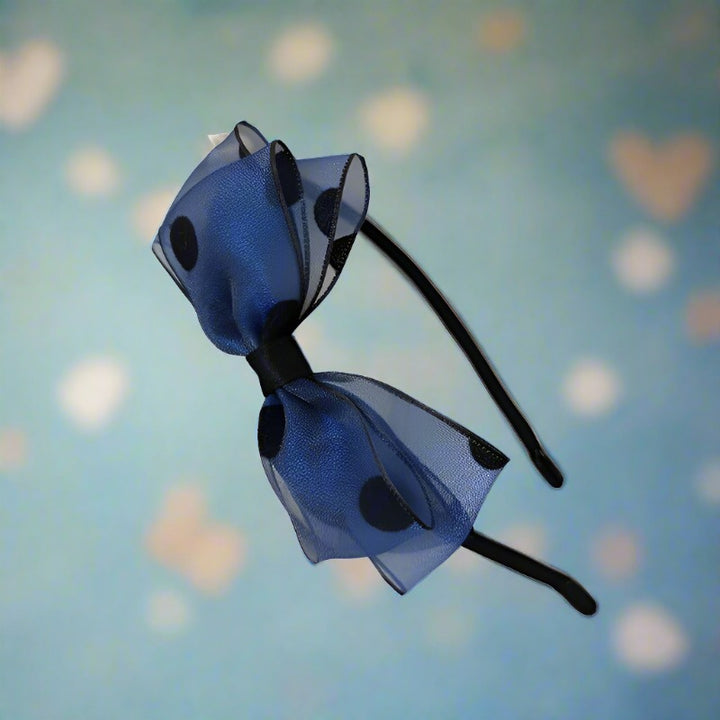 A delightful blue headband adorned with a large, airy silk yarn bow, creating a sophisticated yet fun accessory for any occasion. Ideal for adding a pop of color and elegance.
