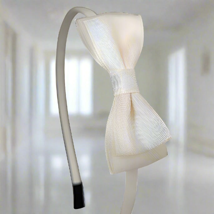 In this side view, the soft sheen of the ivory satin bow is beautifully captured. The mid-size, 7.5 cm double-layer bow complements the sleek iron headband, making it a versatile choice for various occasions.