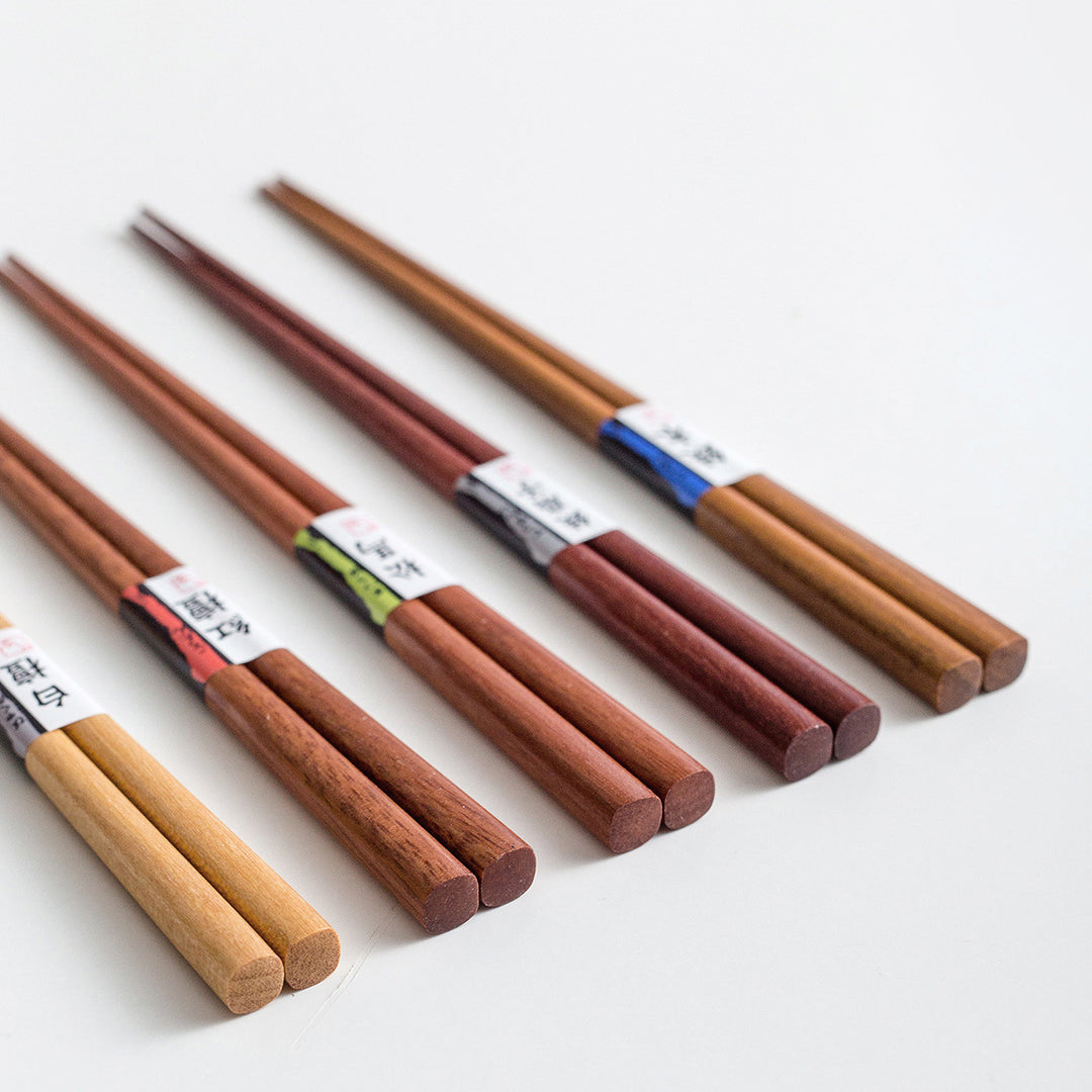 A close-up image highlighting the fine grain and texture differences between the Japanese hop-hornbeam, bamboo iris, pine, red sandalwood, and white sandalwood chopsticks.